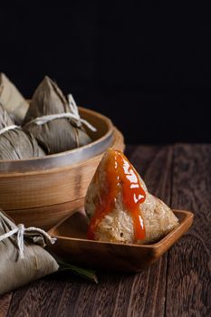 Zongzi. Rice dumpling for Dragon Boat Festival on dark wooden table background.
