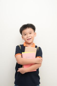 happy male elementary pupil holding books