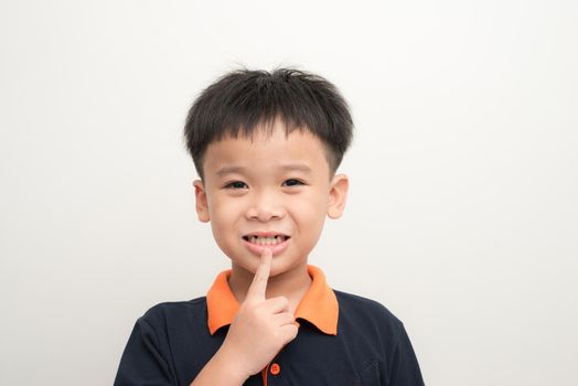 Young happy stylish boy with new tooth instead of missed baby teeth isolated on white background
