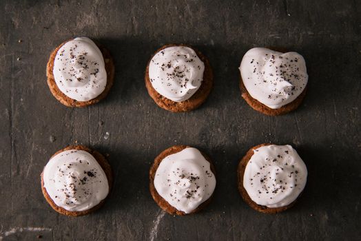 Cookies with cream cheese topping on rustic wooden table