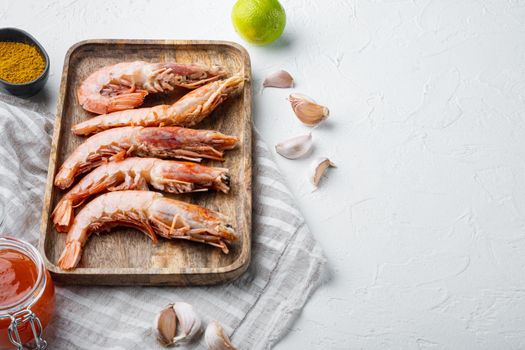Large raw shell on raw king prawns, on wooden tray, on white background , with copyspace and space for text