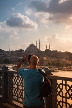 Man  taking pictures on Galata bridge. Vacation in Istanbul. 