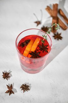 Orange cocktail with rum, liquor, pear slices and thyme on white table, selective focus