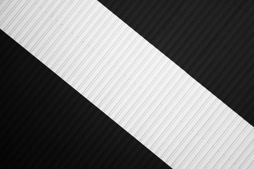 Black and white corrugated iron sheet used as a facade of a warehouse or factory. Texture of a seamless corrugated zinc sheet metal aluminum facade. Architecture. Metal texture.