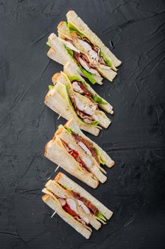 Fresh sandwiches with ingredients, on black background, top view