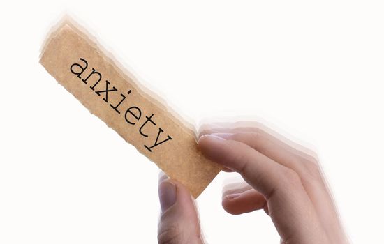  Anxiety wording on blank torn notepaper in hand