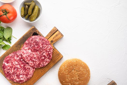 Raw Ground beef meat Burger steak cutlets, on white stone background, top view flat lay, with copy space for text