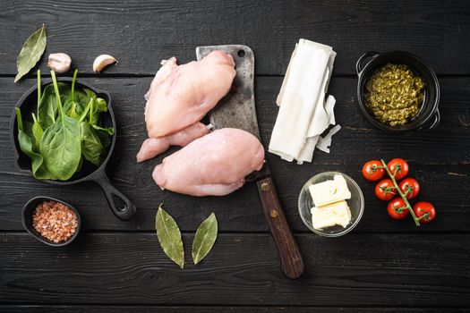 Raw Chicken meat stuffed ingredients with filo, herbs, butter, on black wooden table background, top view flat lay