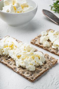 Crisp breads with butter, on white stone table background