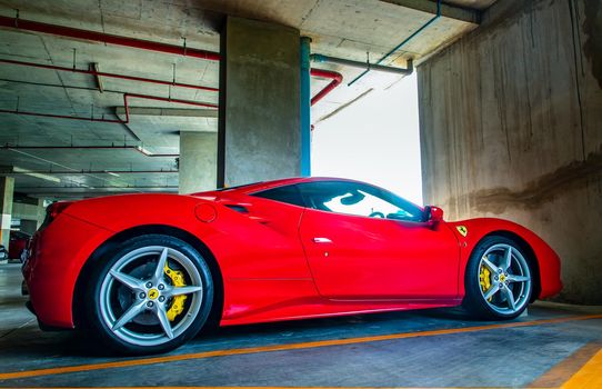 Side view of Red metallic Ferrari car in the parking lot. Ferrari is Italian sports car. 