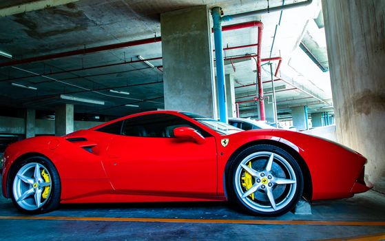 Side view of Red metallic Ferrari car in the parking lot. Ferrari is Italian sports car. 