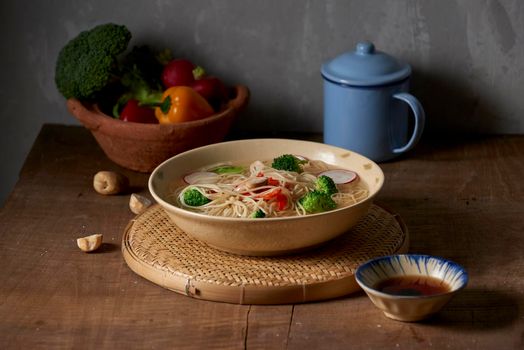 Tasty meat broth with noodles, broccoli and parsley in a bowl