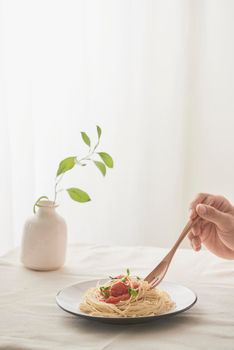 Spaghetti on a fork. Pasta with fresh tomatoes and herbs