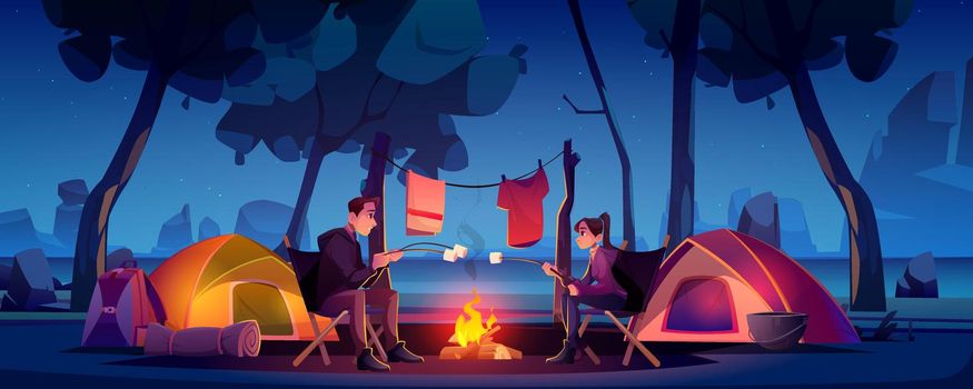 Couple in camp with tent and campfire at night