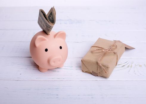 piggy bank and gift on wooden background