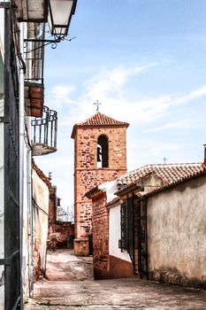 Narrow street with old houses and medieval church in Alcaraz village