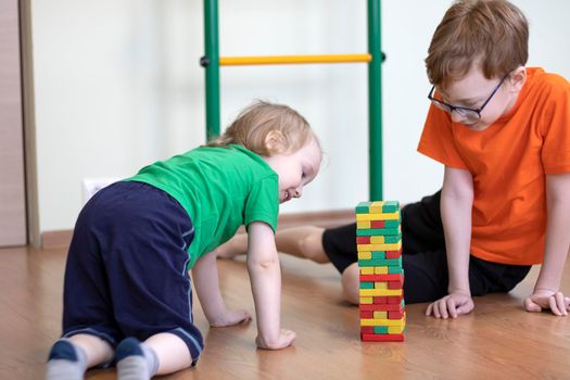 Children play in the playroom in a board game to gather the tower. Two brothers