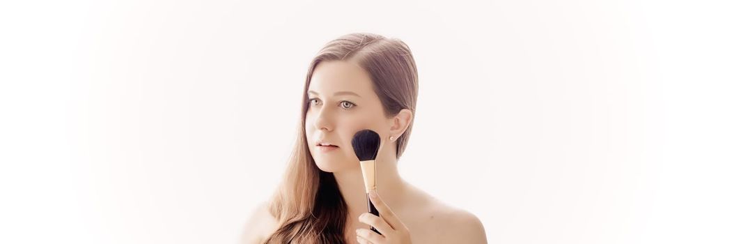 Beautiful woman with makeup brush, perfect skin and shiny hair as make-up, health and wellness concept. Face portrait of young female model for skincare cosmetics and luxury beauty ad design