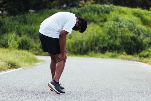 black man running training use hands hold on his knee pain while running