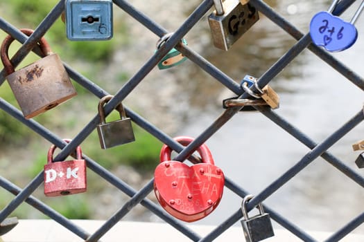 Many colorful love padlocks on fence 