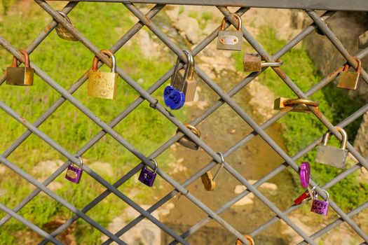 Many colorful love padlocks on fence 