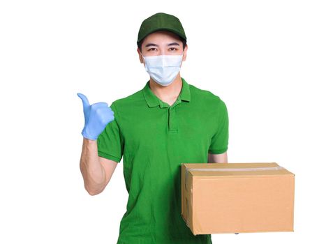 Young courier, employed wearing green clothes and hats, protective masks and gloves to protect himself, delivering packages during the covid-19 epidemic, and making a thumbs-up gesture
