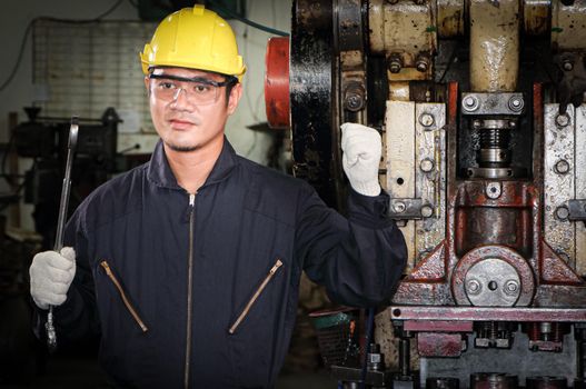 Asian male worker In industries that wear glasses, safety hats and safety uniforms Wrench tool holder stand