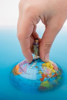 Figurine on the top of the globe in water