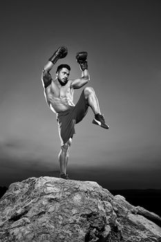 Monochrome shots of a fierce male boxer training outdoors