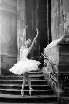 Young ballerina woman posing on stairs