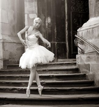 Young ballerina woman posing on stairs