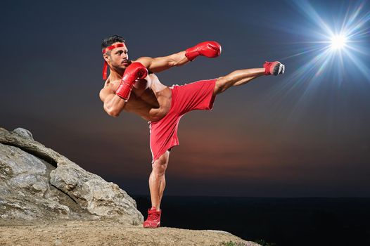 Muscular male boxer training outdoors