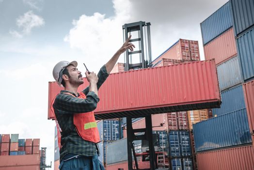 Transport Container Engineer Managing Control Via Walkie Talkie in Containers Shipyard. Container Logistics Shipping Management of Transportation Industry, Business Cargo Ship Import/Export Factory
