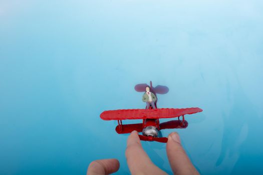 Model airplane and a man figurine in water