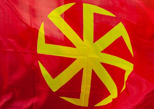 Yellow eight-pointed swastika - Kolovrat on a red background.