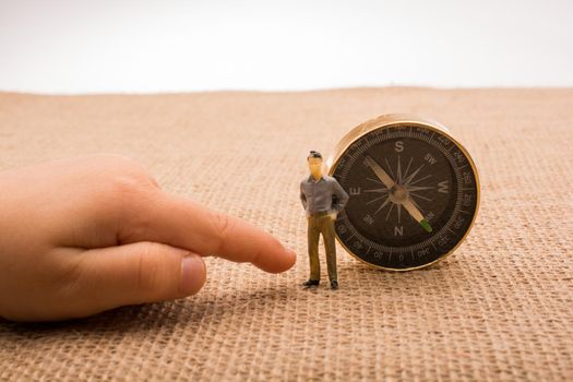 Figurine by the side of a compass