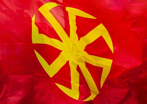 Yellow eight-pointed swastika - Kolovrat on a red background.