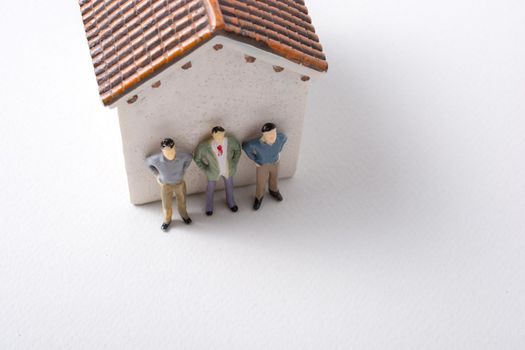 Tiny figurine of men in front of a house