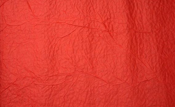 crumpled sheet of red paper, creases and scuffs