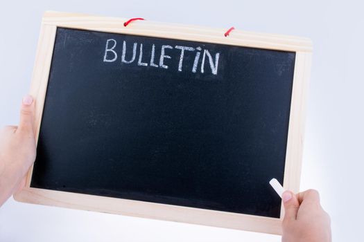 Hand holding the board  with the title of bulletin