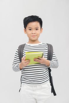 cute elementary school boy holding books on white background