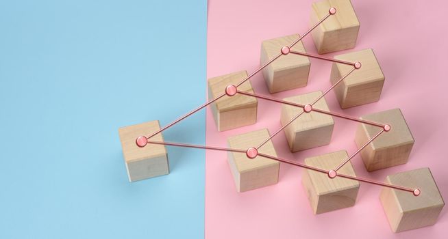 wooden blocks on a pink blue background, hierarchical organizational structure of management