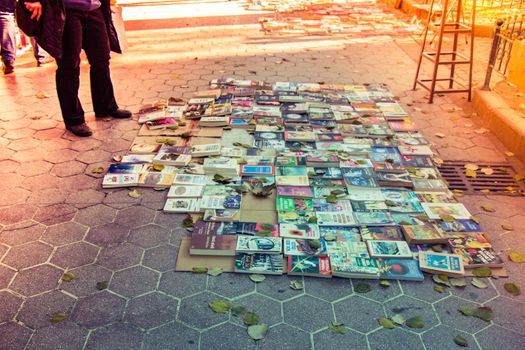 second hand books for sale  laying on the ground in sunlight