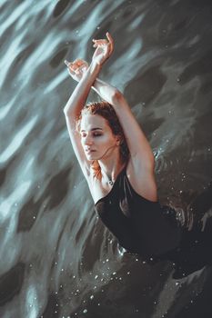 Young beautiful woman standing in the water.