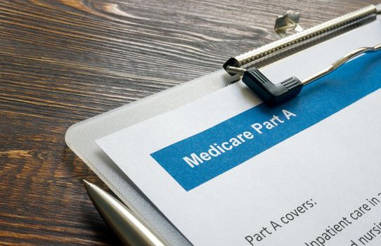 Health Insurance papers about Medicare part A and pen.