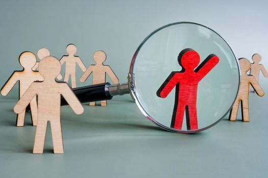 Be unique concept. Talent management with magnifying glass and figurines.