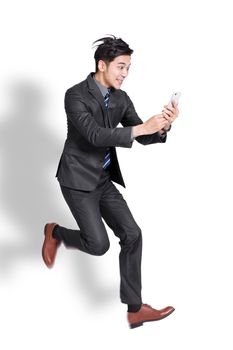 Excited Young handsome businessman  jumping and using mobile phone