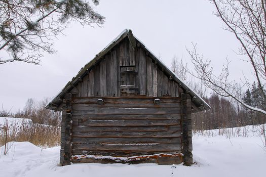 Old wooden building of bathhouse in the village. Traditional exterior oin Russian style.